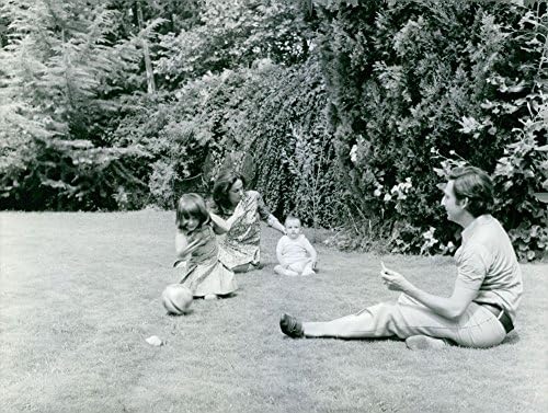 Fotografie de epocă a prințului Michael din Grecia care se joacă cu familia sa în curtea lor.
